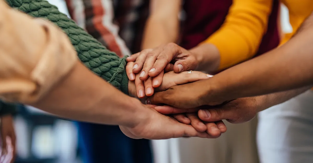 Diverse group of hands joined together